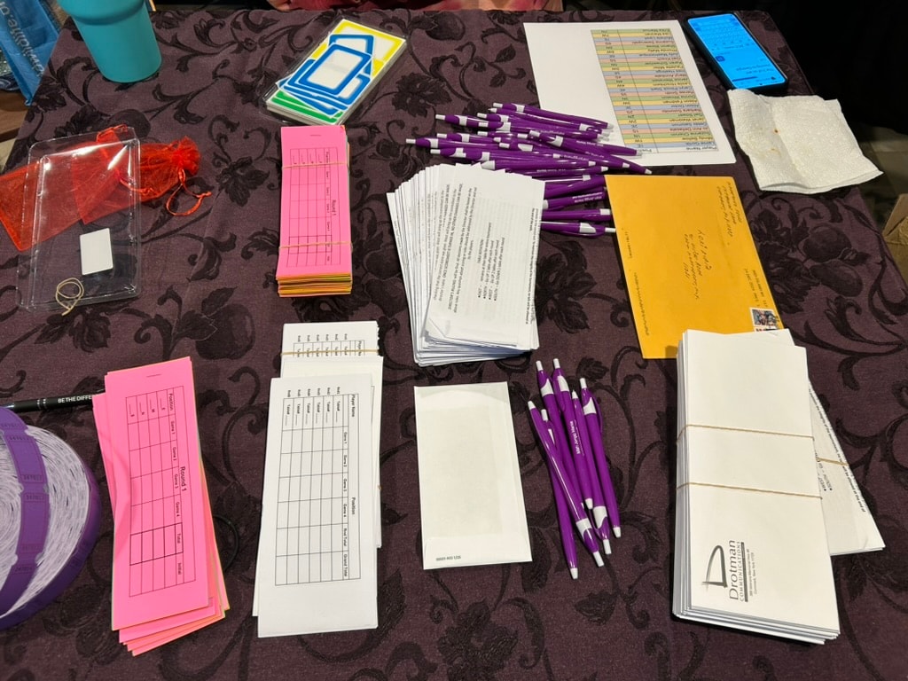 Arrival check-in materials including name tags, score sheets and pens