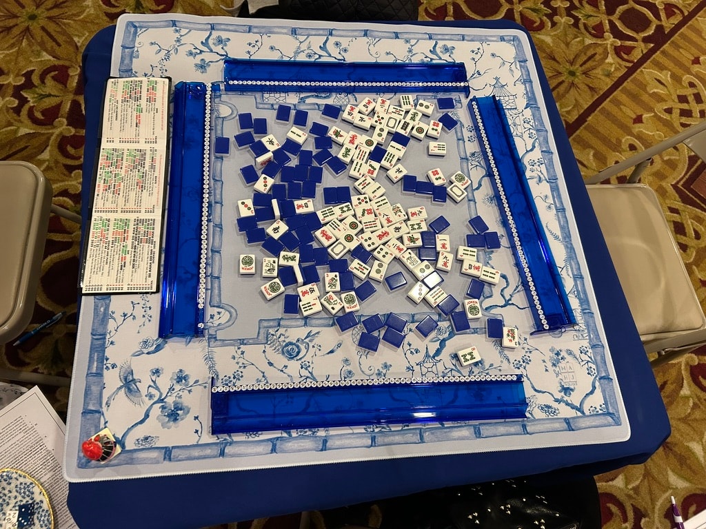 Mah Jongg tournament table with teal tiles on a floral tablecloth